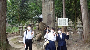 月照寺の亀の前で記念写真を撮る生徒たち