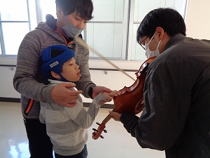 ヴァイオリンを触って響きを感じるすみれの生徒