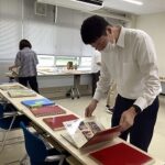 記念誌を見る男性教員